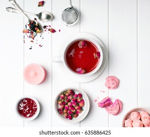 Herbal rose tea, dry roses and other pink colored objects on white wooden table, top view - Powered by Shutterstock