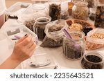 Herbal tea collection. Glass jars with lids. Master class on cooking, training. The hands of the participants are large against the background of jars and bowls with herbs. Ecological, clean.