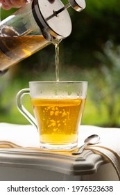 Herbal tea in glass cup served in garden. Outdoor garden breakfast in summer