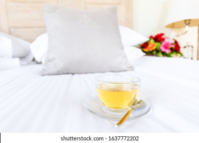 Herbal tea on bed linen in the upscale hotel room. Being alone, getaway, staycation, digital detox concepts. Horizontal - Shutterstock ID 1637772202