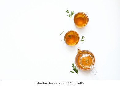 Herbal tea with rosemary in a glass teapot on a white background. Top view
