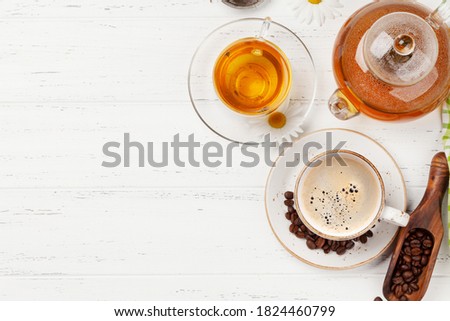 Herbal tea in teapot and cup and espresso coffee on wooden table. Top view with copy space. Flat lay