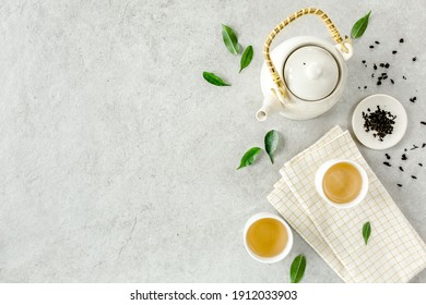 Herbal Tea With Two White Tea Cups And Teapot, With Green Tea Leaves. Flat Lay, Top View. Tea Concept