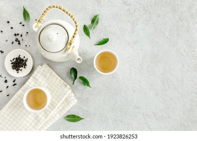 Herbal tea with two white tea cups and teapot, with green tea leaves. Flat lay, top view. Tea concept - Shutterstock ID 1923826253