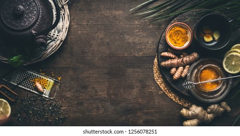 Herbal turmeric tea background. Cup of healthy turmeric spice tea with iron teapot and ingredients:  lemon,  ginger, cinnamon sticks and honey , top view frame with copy space. Immune boosting remedy  - Powered by Shutterstock