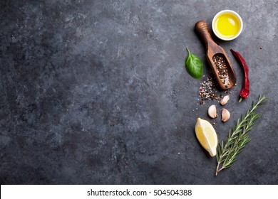 Herbs and spices. Cooking ingredients. Rosemary, basil, olive oil, salt and pepper. Top view over stone table with copy space for your recipe - Powered by Shutterstock