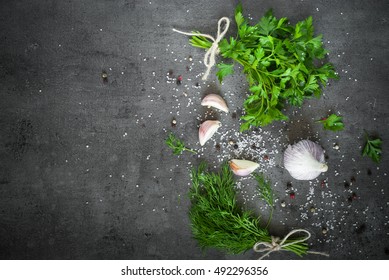 Herbs And Spices At Dark Slate Table. Parsley, Dill, Garlic And Pepper. Ingredients For Cooking.