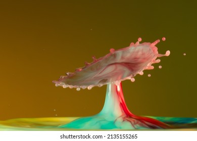 Here is a collision photo of water drops on a yellow background in a liquid composed of different dyes. It is necessary to use a particular and precise technique to obtain a good result.