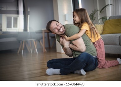 Here Comes The Tickle Monster. Little Girl Playing With Her Father At Home.