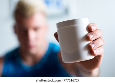 Here It Is. Selective Focus Of A Jar With Bodybuilding Supplement In Hands Of A Strong Man Holding It
