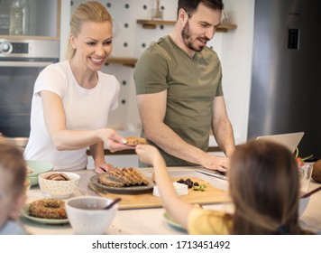 Here You Go. Family In Kitchen Having Breakfast. Focus Is On Background.