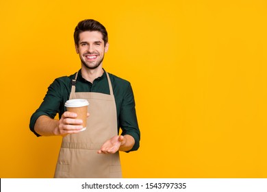 Here your latte! Portrait of positive cheerful guy student work part-time in coffee bar shop give to client paper card disposable mug wear stylish trendy outfit isolated over yellow color background - Powered by Shutterstock