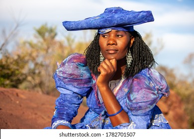 Herero Woman Wearing A Victorian Style Dress Outdoors In A Village In North Botswana