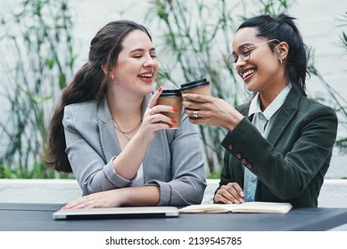 Heres To Becoming Better And Better. Shot Of Two Young Businesswomen Toasting With Coffee During A Business Meeting.