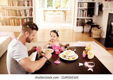 Heres A Cookie For You Too Dad. Shot Of A Father And His Little Daughter Having A Tea Party Together At Home.
