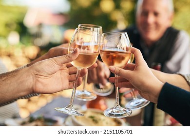 Heres to many more gatherings like this. Shot of a group unrecognizable people celebrating with a toast over a dinner table outside. - Powered by Shutterstock