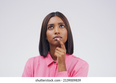 Heres Some Brain Food.... Studio Shot Of A Young Woman Looking Thoughtful Against A Gray Background.