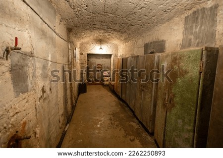 Hermetic rusty door of the bunker in underground abandoned tunnel. Mysterious old iron gate. Secret entrance