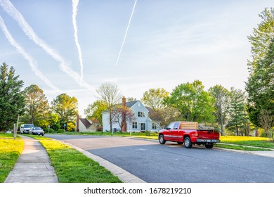 Herndon, USA - April 23, 2019: Northern Virginia Fairfax county residential neighborhood in spring with houses and road cars parked by lawn and sidewalk