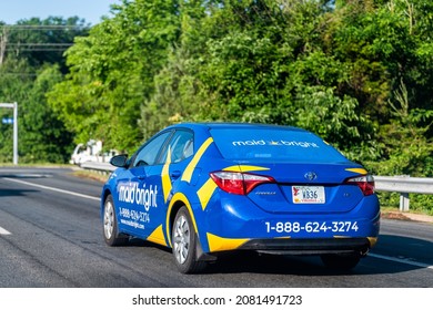 Herndon, USA - May 27, 2021: Northern Virginia Fairfax county with maid bright van for home cleaning residential service with blue yellow logo on car on street road