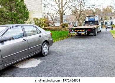 Herndon, USA - November 21, 2020: Parked Car In Driveway With Tower Man Walking To Tow Vehicle Due To Fuel Leak That Damaged Pavement Covered In Cat Litter To Absorb The Gas