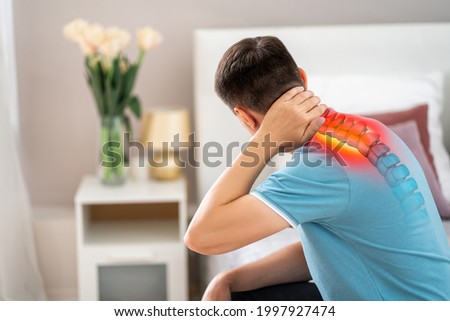 Hernia of the cervical spine, neck pain, man suffering from ache in the bedroom, compression injury of the intervertebral disc, health problems concept