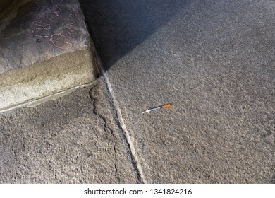 Heroin Needle On The Cement Ground