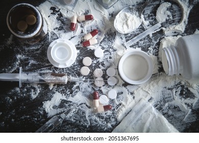 Heroin Powder, Pills And Syringe On The Dark Background.