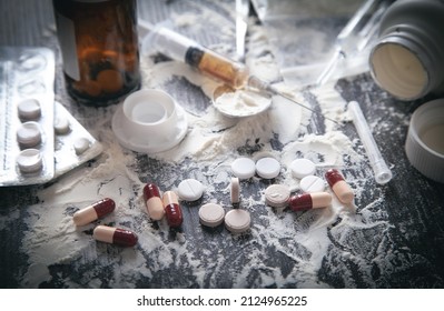 Heroin Powder, Pills And Syringe On The Dark Background.