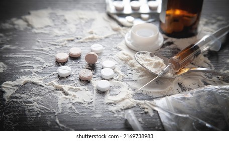 Heroin Powder, Pills And Syringe On The Dark Background.