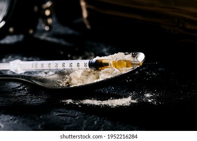 Heroin In A Syringe And Heroin Powder On A Black Background. The Concept Of A Narcotic Substance.