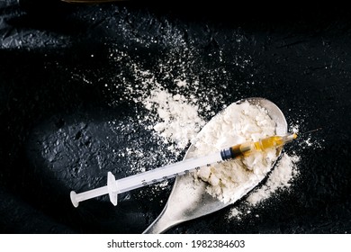 Heroin In A Syringe And Heroin Powder On A Black Background. The Concept Of A Narcotic Substance.