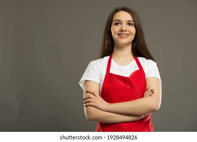 Heroshot eines schönen jungen Supermarktangestellten mit rotem Schürze