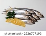 Herring or Baltic herring (Clupea harengus membras) on a white background with lemon and celery leaves