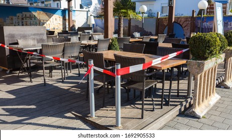 Herrsching, Bavaria / Germany - Apr 1, 2020: Patio Of A Restaurant With Chairs & Tables. Closed Off With Red - White Tape. Closed Due To Restrictions Related To The Coronavirus (Covid-19). No People.