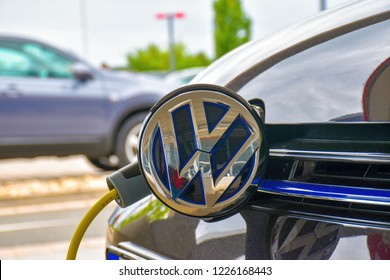 Herzogenaurach, Germany - June 23, 2018: A Volkswagen Golf GTE is charged at a charging station. The charging plug is plugged into the socket hidden behind the brand logo.