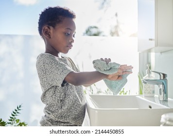 Hes a clean kid. Shot of a little boy drying his hands with a towel in a bathroom at home. - Powered by Shutterstock