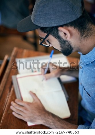 Hes concentrated on the task. Cropped shot of an university student writing notes in class.