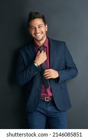 Hes Full Of Ambition. Portrait Of A Handsome Young Businessman Standing Against A Black Background.