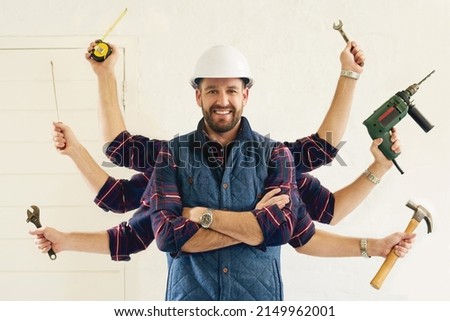 Hes got all the tools youll need. Portrait of a handsome young handyman tools in multiple hands.