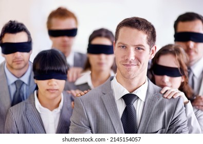 Hes got the knowledge to get ahead of the pack. A young businessman standing in front of a group of blindfolded businesspeople.
