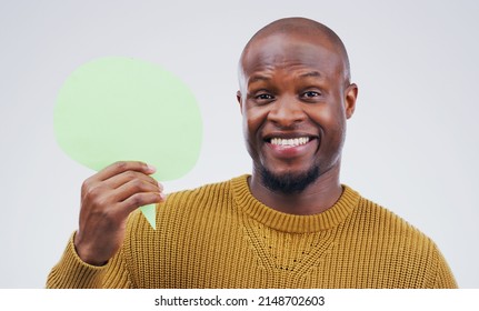 Hes Got A Message For The World Today. Portrait Of A Handsome Young Man Holding A Speech Bubble Against A Grey Background.