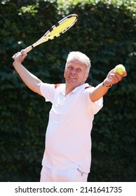 Hes Got A Wicked Serve. A Senior Man Serving While Playing Tennis.