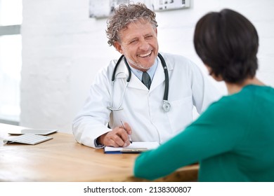 Hes Got A Wonderful Bedside Manner. Shot Of A Smiling Mature Doctor Having A Consultation With A Patient.