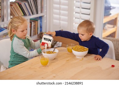 Hes So Helpful. Shot Of A Young Brother And Sister Making Breakfast At Home.