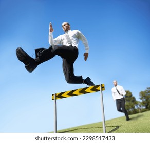 Hes jumping over all the obstacles that are int he way of his success. A businessman jumping over a hurdle. - Powered by Shutterstock