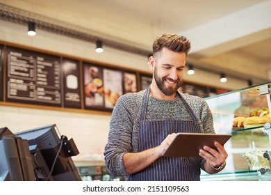 Hes just launched an app for his business. Cropped shot of a business owner using a digital tablet in his cafe.
