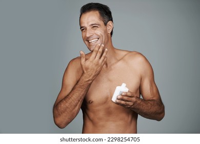 Hes a man that cares about skincare. Studio shot of a handsome mature man applying moisturizer to his skin. - Powered by Shutterstock