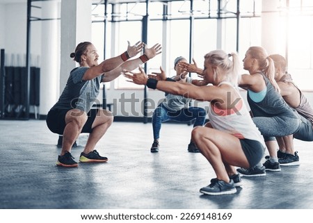 Hes the one to get you in shape. Shot of a fitness instructor working with a group of people at the gym.