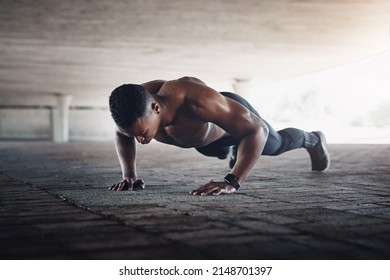 Hes one strong man. Full length shot of a handsome young man doing pushups while exercising outside.